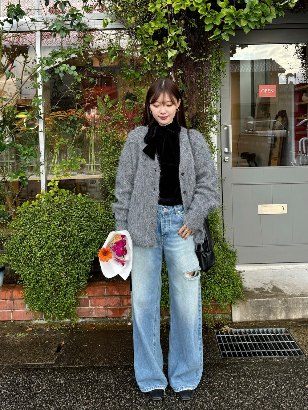 ブラック系のTシャツ/カットソー、グレー系のカーディガン/ボレロ、ブルー系のデニムパンツを着用したレディースの冬コーディネートの2枚目の写真