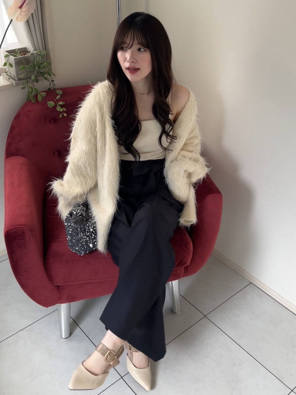 ベージュ系のカーディガン/ボレロ、グレー系のスラックスを着用したレディースの冬コーディネートの2枚目の写真