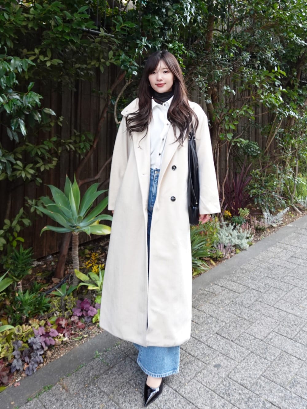 ホワイト系のその他アウター、ブラック系のショルダーバッグを着用したレディースの冬コーディネートの2枚目の写真