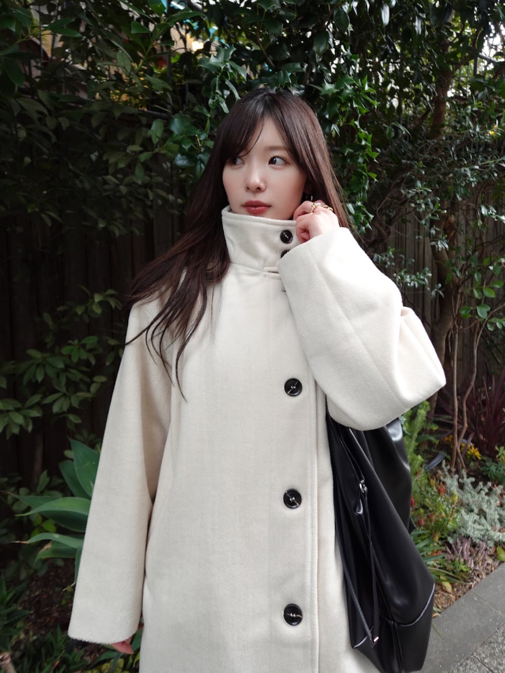 ホワイト系のその他アウター、ブラック系のショルダーバッグを着用したレディースの冬コーディネートの4枚目の写真