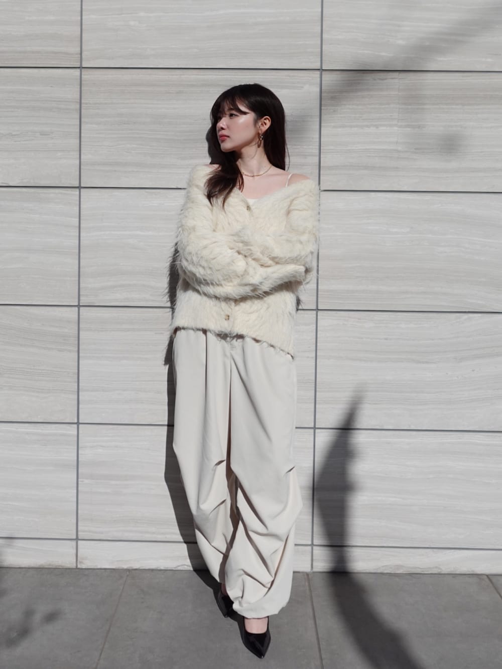 ベージュ系のカーディガン/ボレロ、ホワイト系のカーゴパンツを着用したレディースの冬コーディネートの2枚目の写真