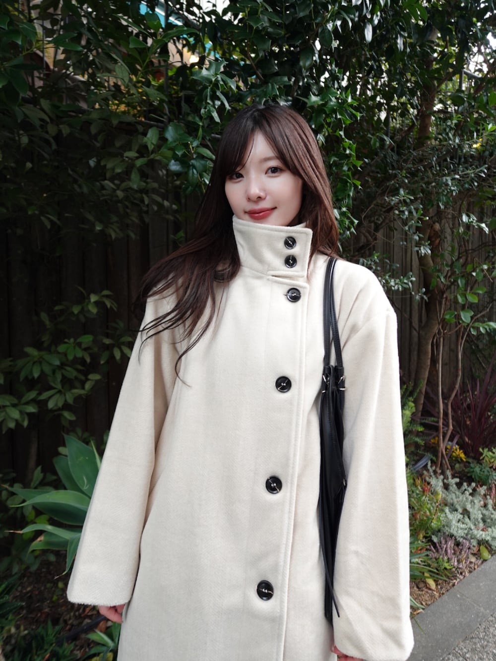 ホワイト系のその他アウター、ブラック系のショルダーバッグを着用したレディースの冬コーディネートの3枚目の写真