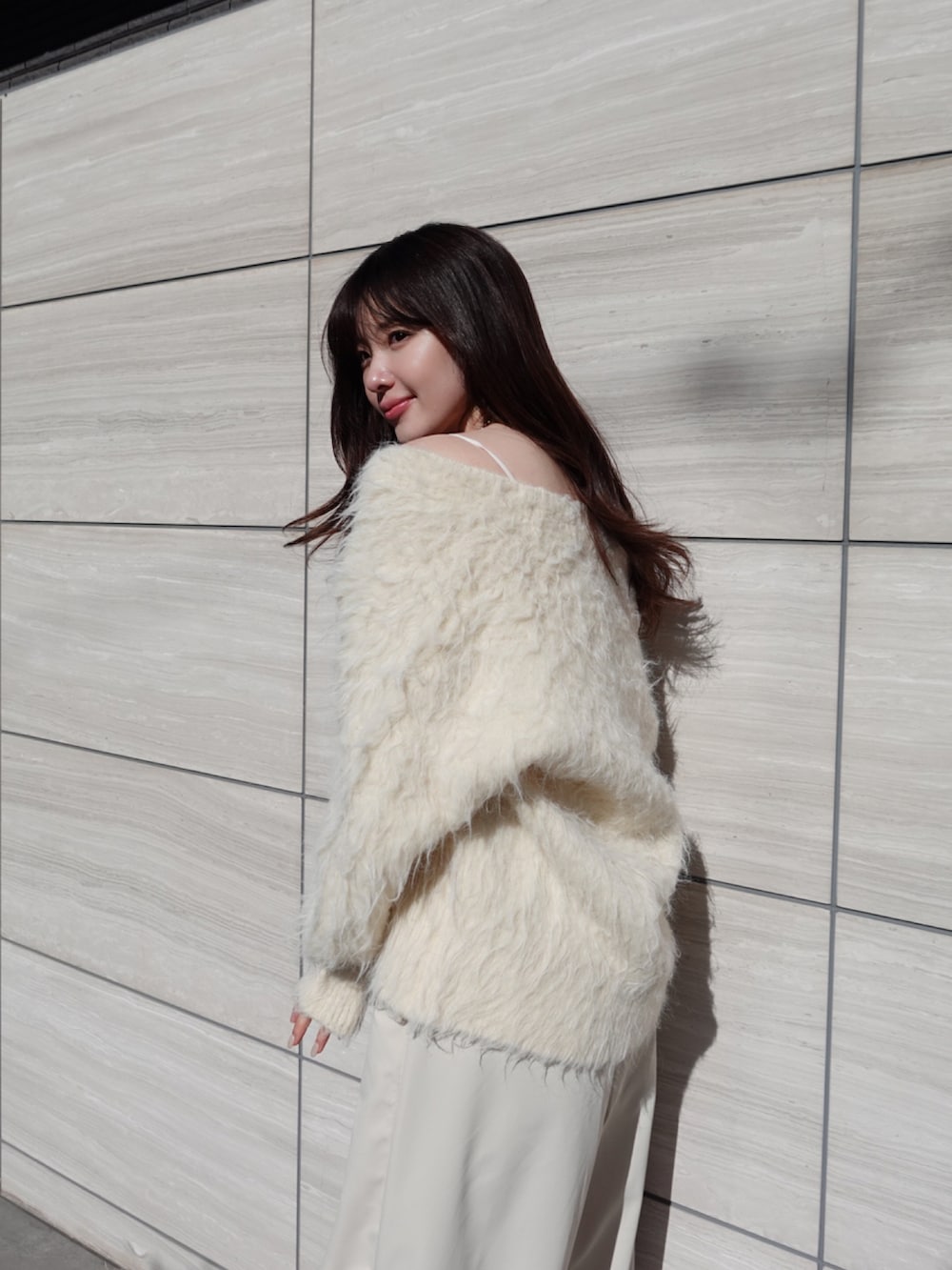 ベージュ系のカーディガン/ボレロ、ホワイト系のカーゴパンツを着用したレディースの冬コーディネートの3枚目の写真