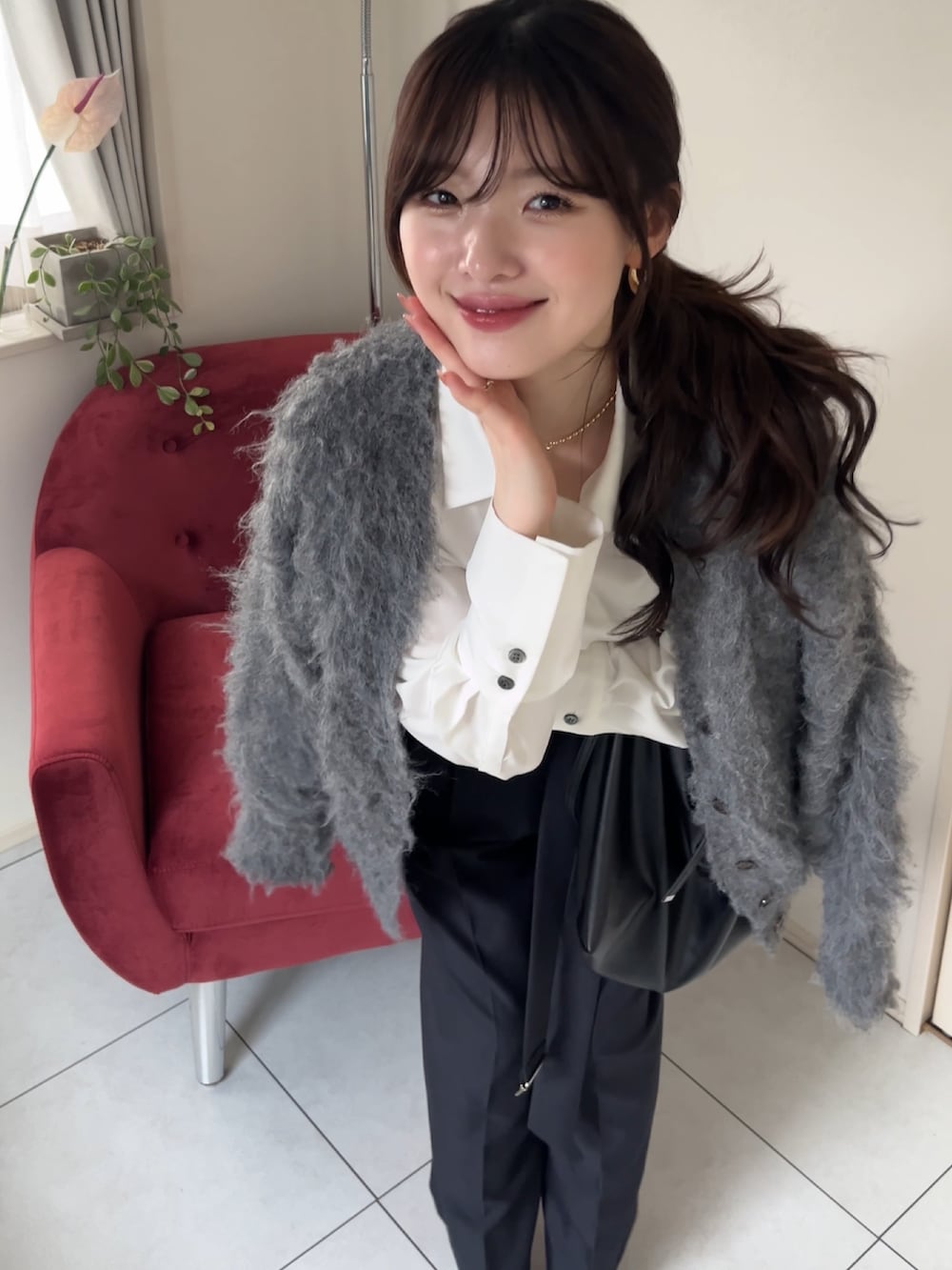 グレー系のスラックス、ブラック系のショルダーバッグ、ホワイト系のシャツ/ブラウスを着用したレディースの冬コーディネートの3枚目の写真