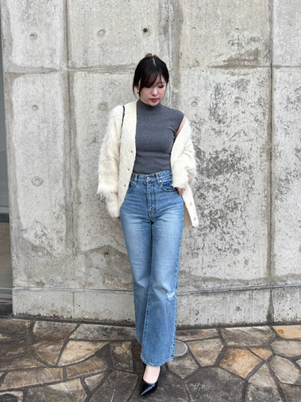 ブルー系のデニムパンツ、グレー系のTシャツ/カットソー、ベージュ系のカーディガン/ボレロを着用したレディースの冬コーディネートの2枚目の写真