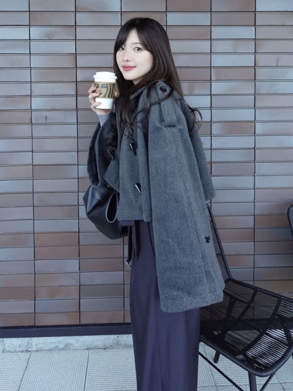 グレー系のスラックスを着用したレディースの冬コーディネートの2枚目の写真