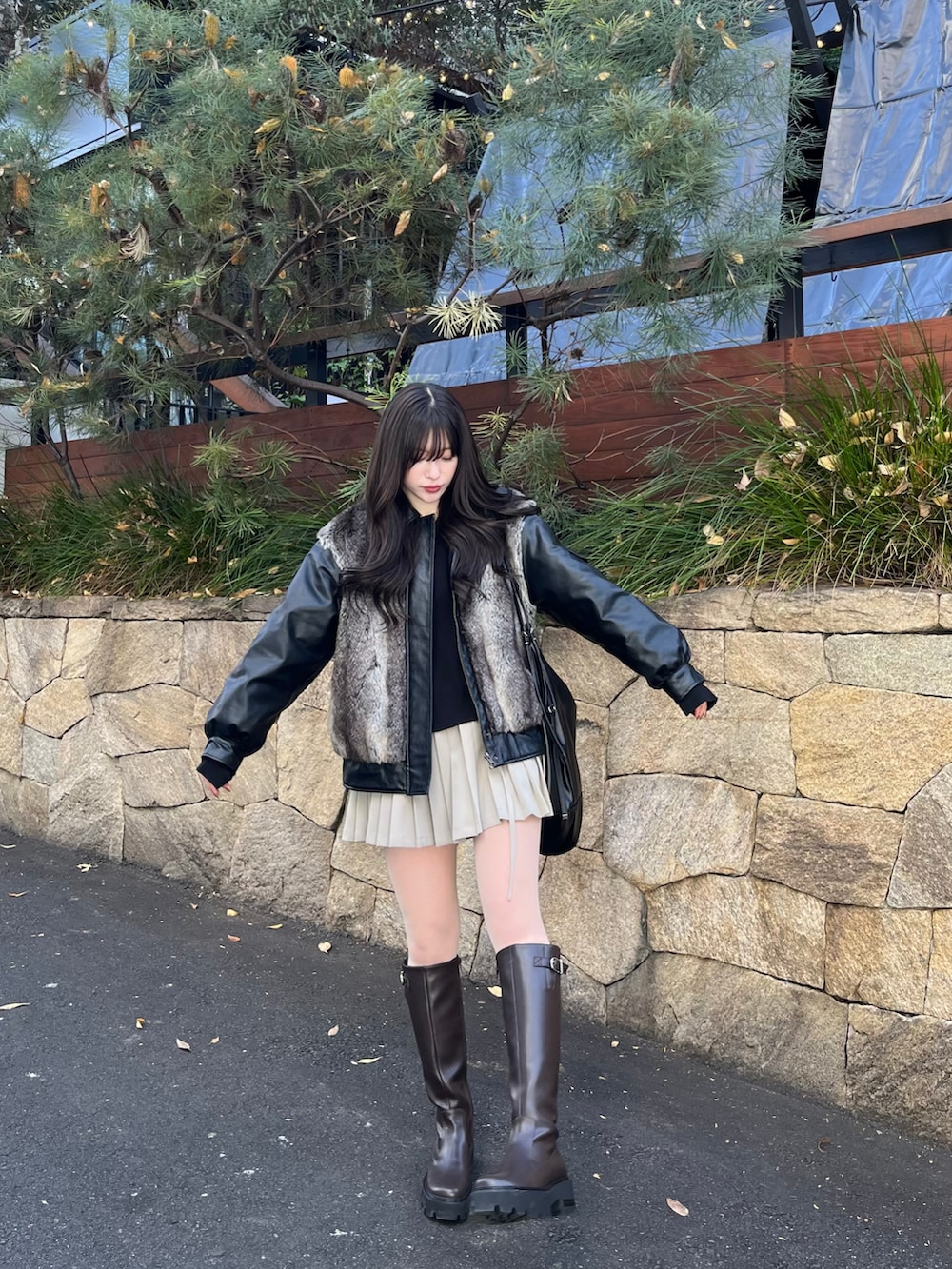 ブラック系のその他アウター、ブラック系のショルダーバッグ、ベージュ系のスカートを着用したレディースの冬コーディネートの3枚目の写真