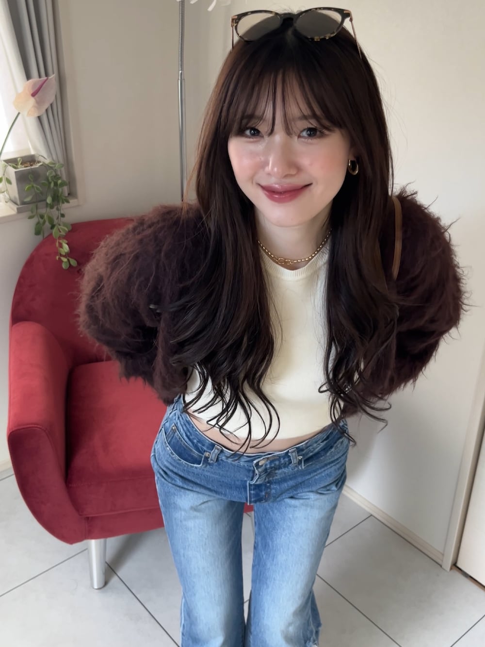 ブラウン系のカーディガン/ボレロ、ホワイト系のTシャツ/カットソー、ブルー系のデニムパンツを着用したレディースの冬コーディネートの3枚目の写真