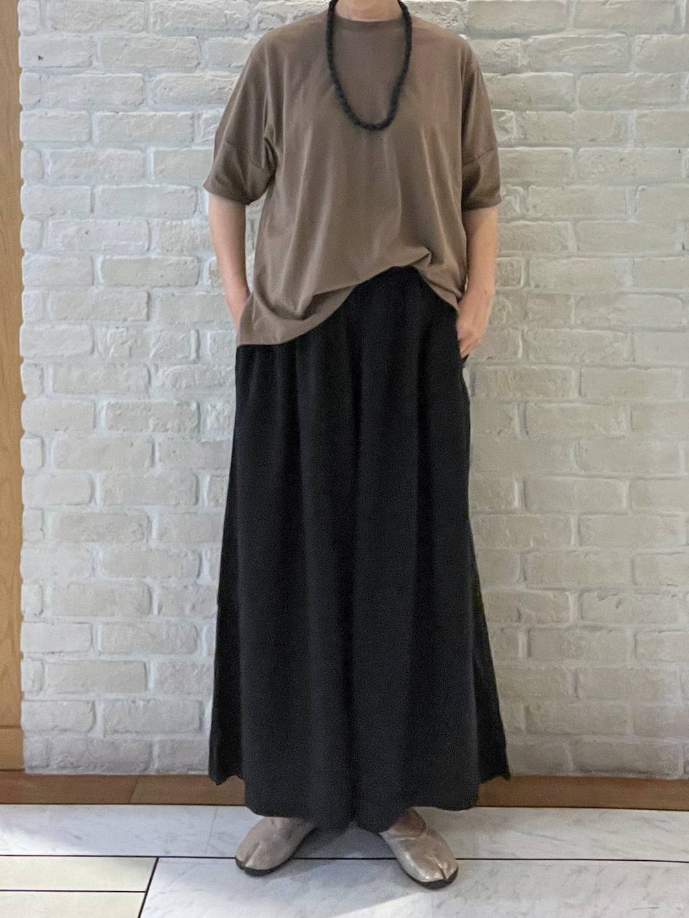 ブラック系のその他パンツ、ブラウン系のTシャツ/カットソー、ブラック系のネックレスを着用したレディースの夏コーディネートの5枚目の写真