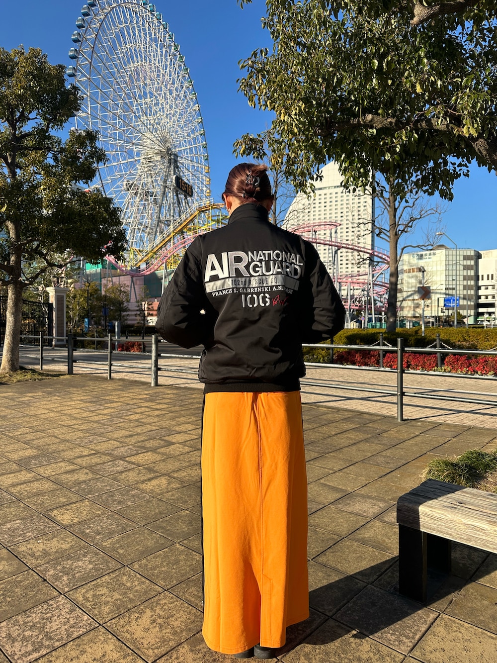 ブラック系のMA-1、オレンジ系のスカートを着用したレディースの冬コーディネートの2枚目の写真