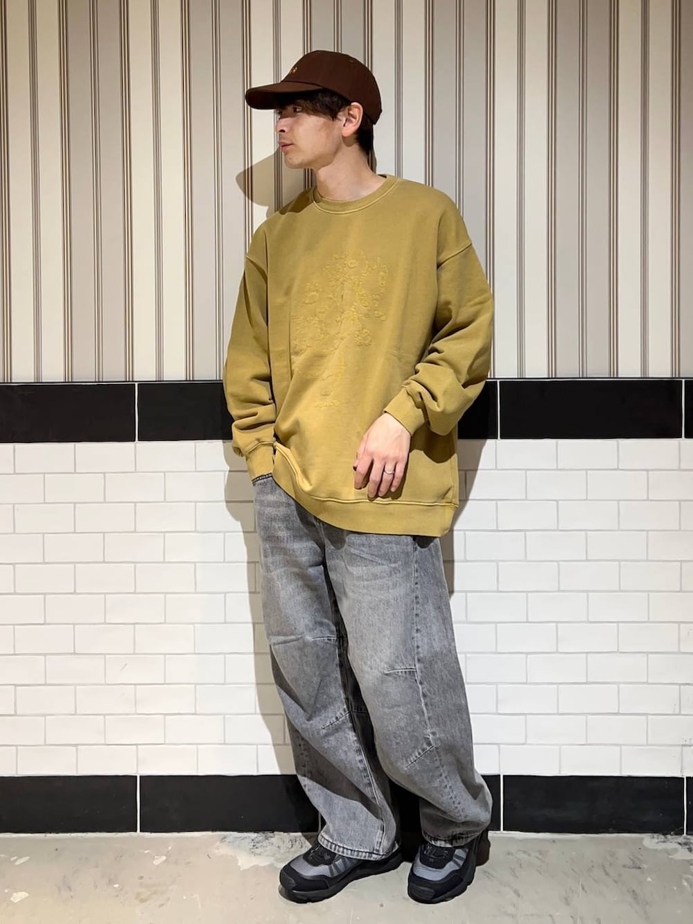 ブラック系のブルゾン、グレー系のデニムパンツ、ブラック系のスニーカーを着用したメンズの秋コーディネートの5枚目の写真