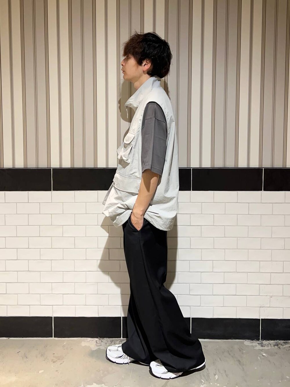 ホワイト系のスニーカー、グレー系のTシャツ/カットソー、ブラック系のスラックスを着用したメンズの夏コーディネートの3枚目の写真