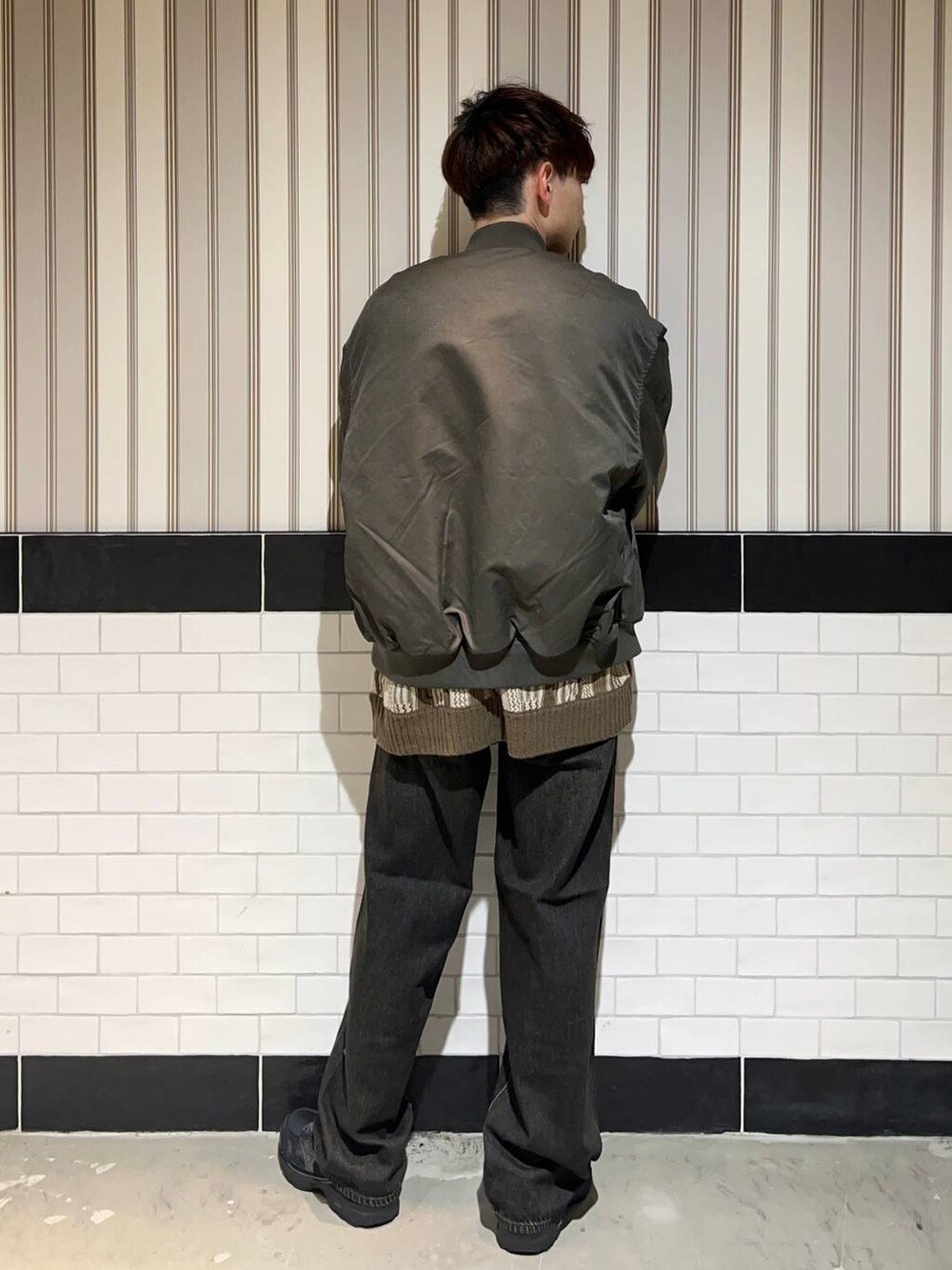ブラック系のスニーカー、グリーン系のMA-1、グレー系のデニムパンツを着用したメンズの冬コーディネートの6枚目の写真