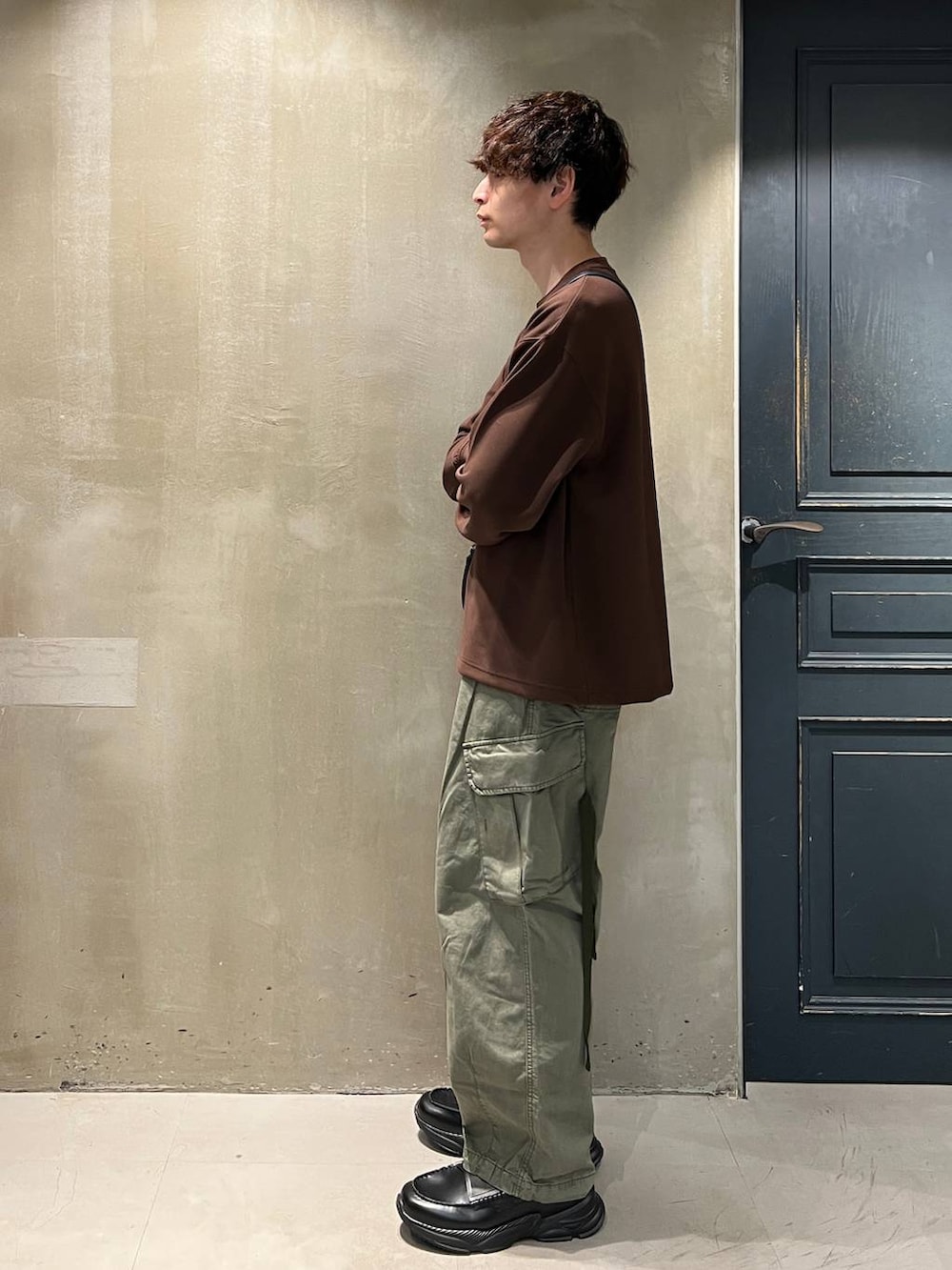 グリーン系のカーゴパンツ、ブラック系のショルダーバッグ、ブラック系のローファーを着用したメンズの夏コーディネートの5枚目の写真