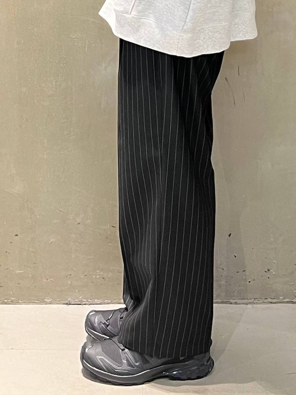 ブラック系のスニーカー、ブラック系のスラックス、その他のパーカーを着用したメンズの春コーディネートの5枚目の写真