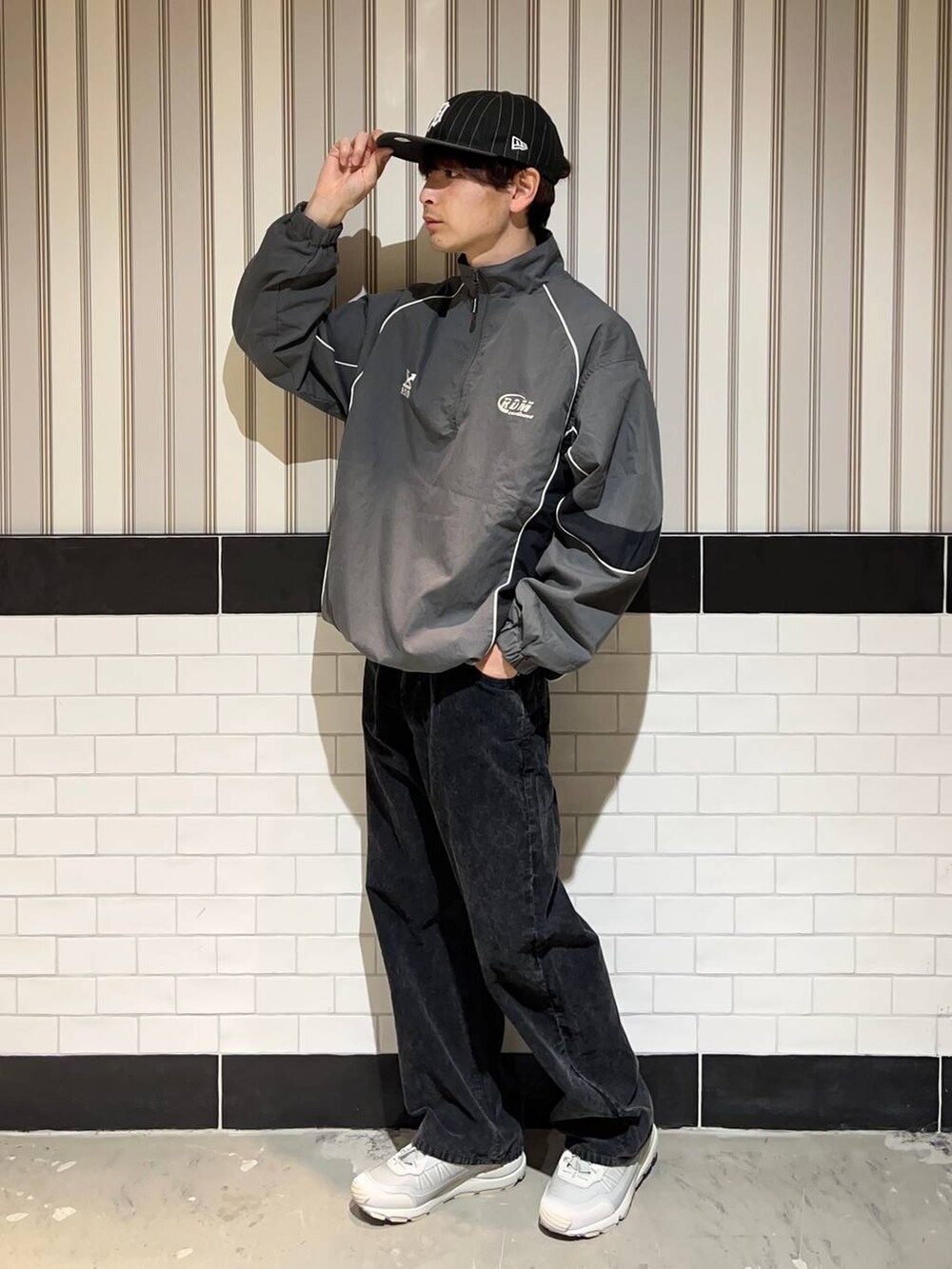 グレー系のスニーカー、グレー系のスウェット、ブラック系のキャップを着用したメンズの秋コーディネートの2枚目の写真