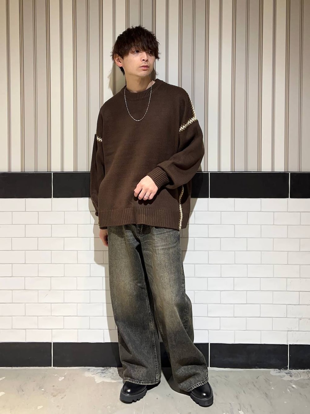 ブラック系のドレスシューズ、ブラウン系のニット/セーター、グレー系のデニムパンツを着用したメンズの冬コーディネートの4枚目の写真