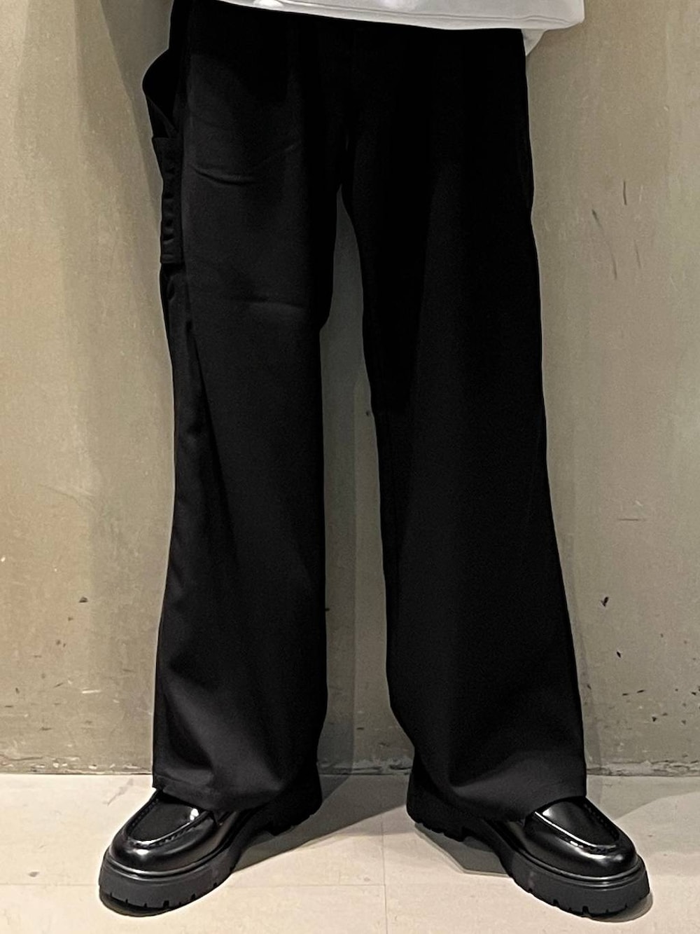 ブラック系のスラックス、グレー系のスウェット、ブラック系のキャップを着用したメンズの秋コーディネートの3枚目の写真