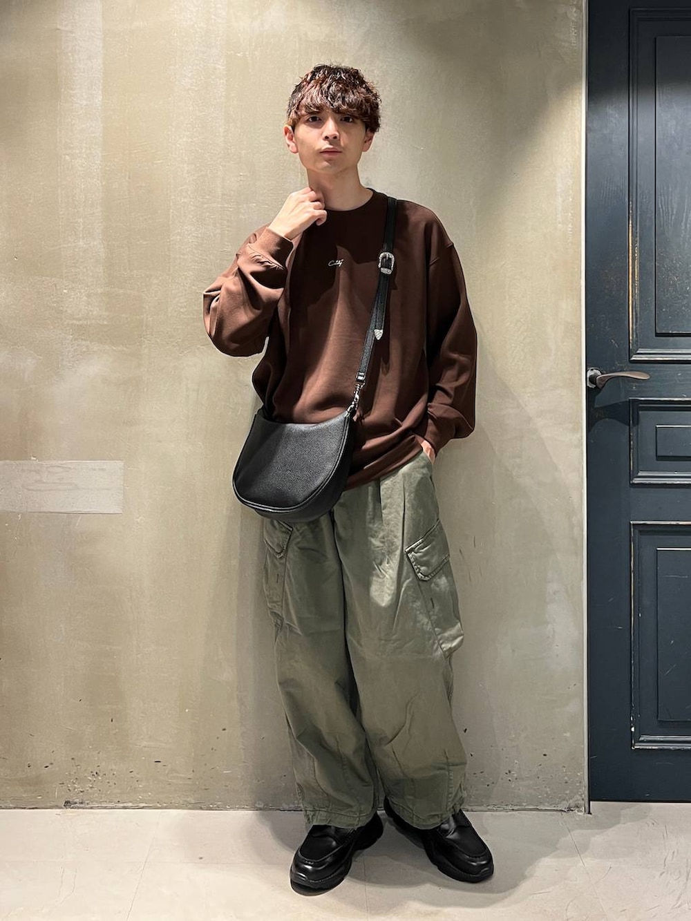 グリーン系のカーゴパンツ、ブラック系のショルダーバッグ、ブラック系のローファーを着用したメンズの夏コーディネートの2枚目の写真