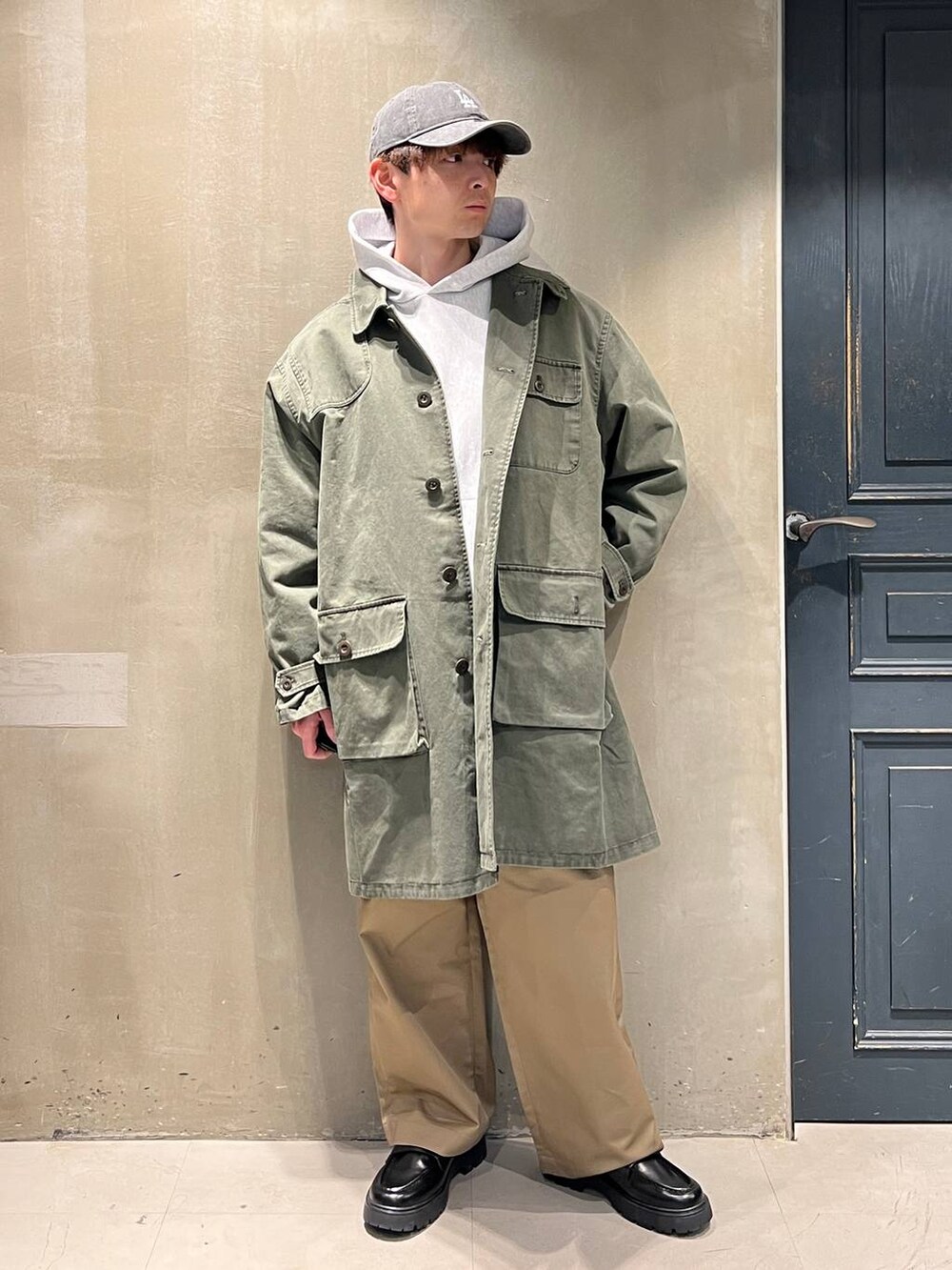ベージュ系のチノパンツ、ブラック系のドレスシューズ、グレー系のスウェットを着用したメンズの冬コーディネートの2枚目の写真