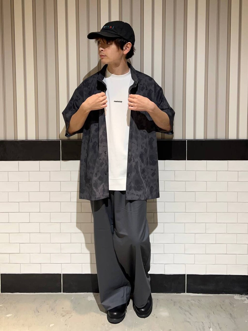 ブラック系のドレスシューズ、グレー系のスラックス、ホワイト系のTシャツ/カットソーを着用したメンズの夏コーディネートの5枚目の写真