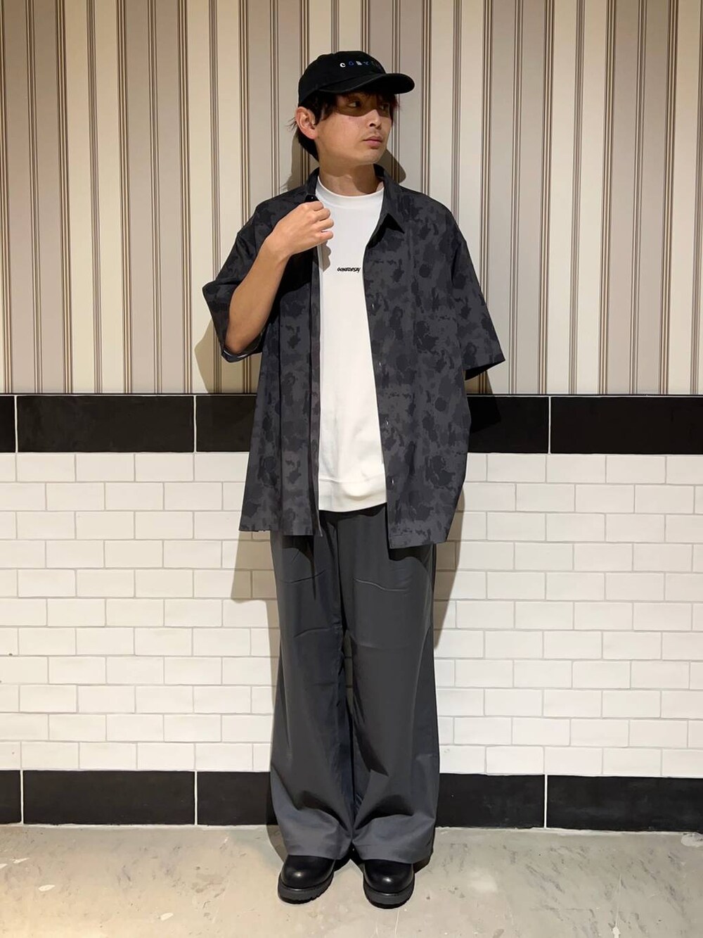 ブラック系のドレスシューズ、グレー系のスラックス、ホワイト系のTシャツ/カットソーを着用したメンズの夏コーディネートの2枚目の写真