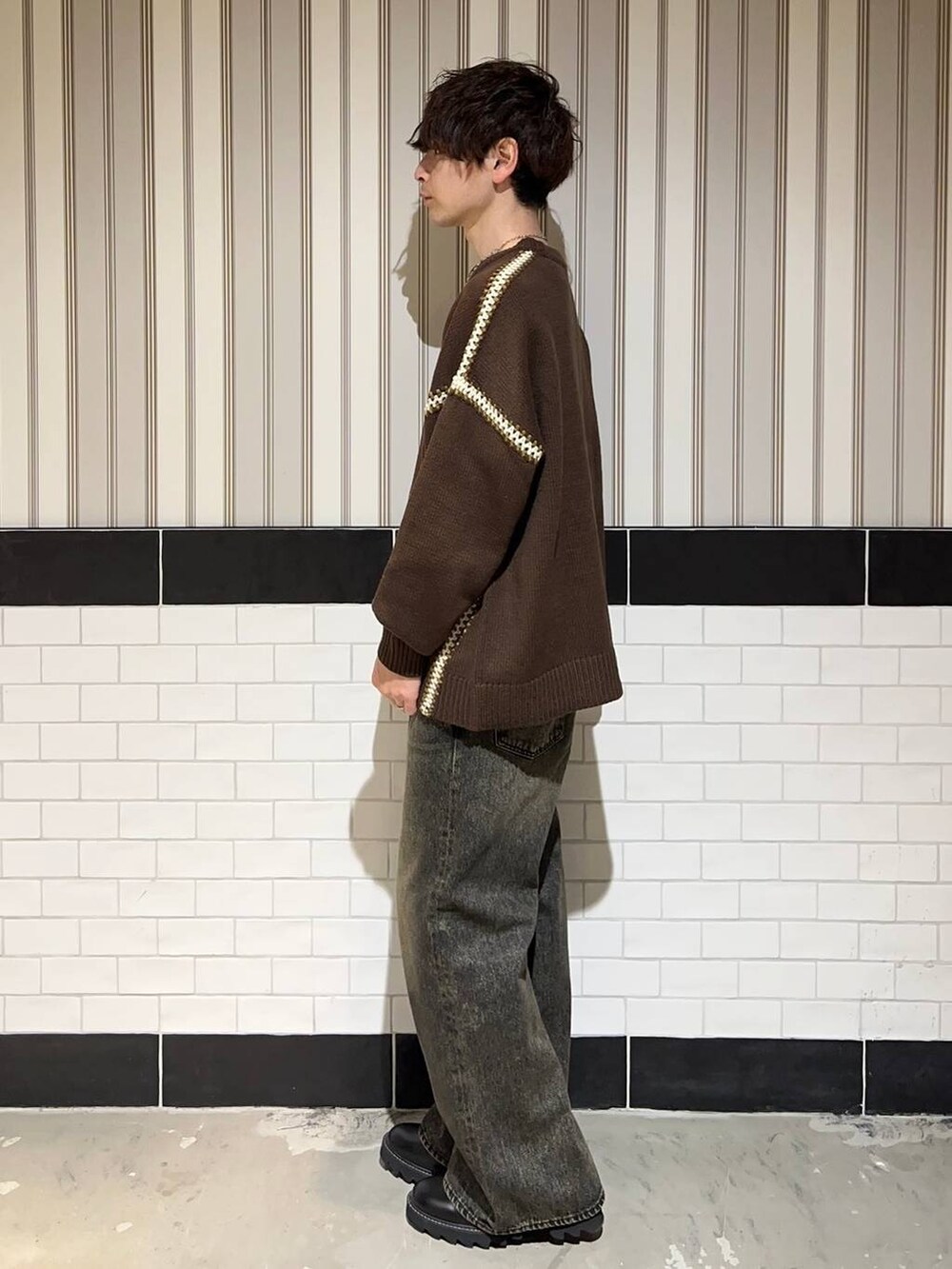 ブラック系のドレスシューズ、ブラウン系のニット/セーター、グレー系のデニムパンツを着用したメンズの冬コーディネートの5枚目の写真