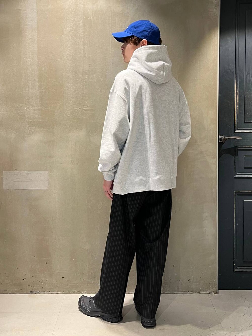 ブラック系のスニーカー、ブラック系のスラックス、その他のパーカーを着用したメンズの春コーディネートの8枚目の写真