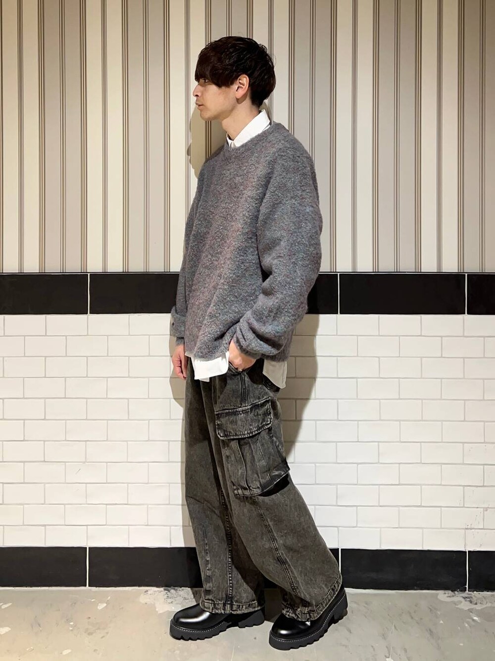 グリーン系のニット/セーター、ブラック系のドレスシューズ、ホワイト系のシャツ/ブラウスを着用したメンズの冬コーディネートの4枚目の写真