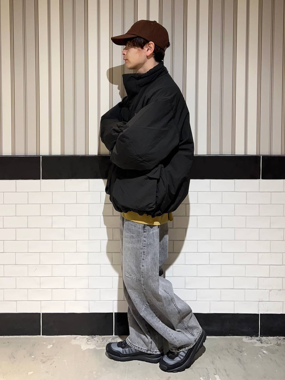 ブラック系のブルゾン、グレー系のデニムパンツ、ブラック系のスニーカーを着用したメンズの秋コーディネートの9枚目の写真