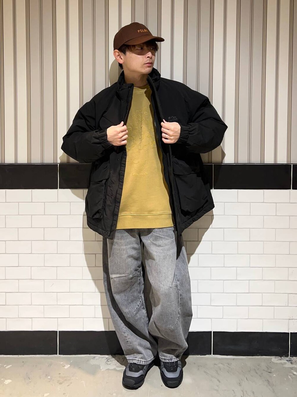 ブラック系のブルゾン、グレー系のデニムパンツ、ブラック系のスニーカーを着用したメンズの秋コーディネートの7枚目の写真