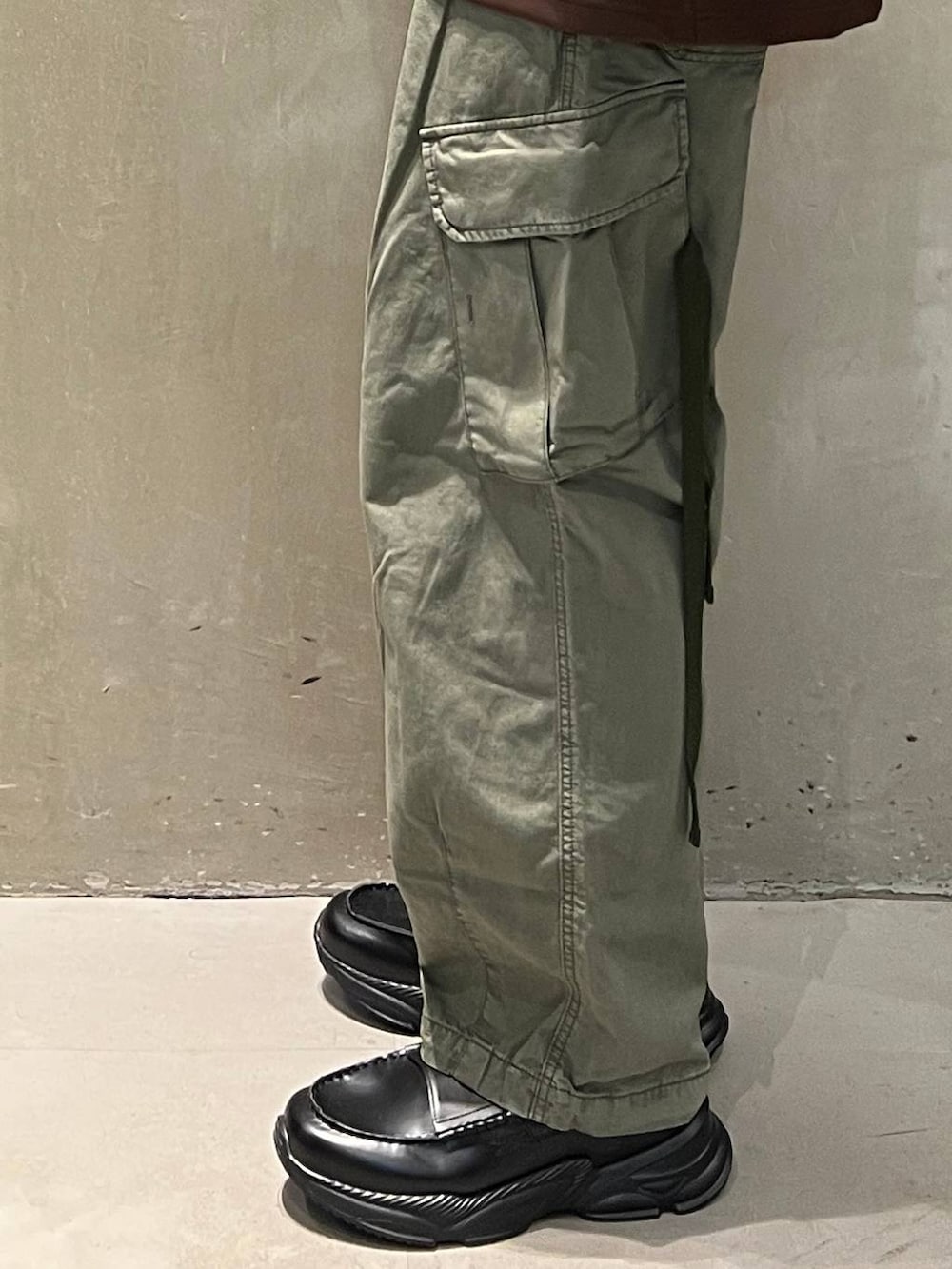 グリーン系のカーゴパンツ、ブラック系のショルダーバッグ、ブラック系のローファーを着用したメンズの夏コーディネートの6枚目の写真