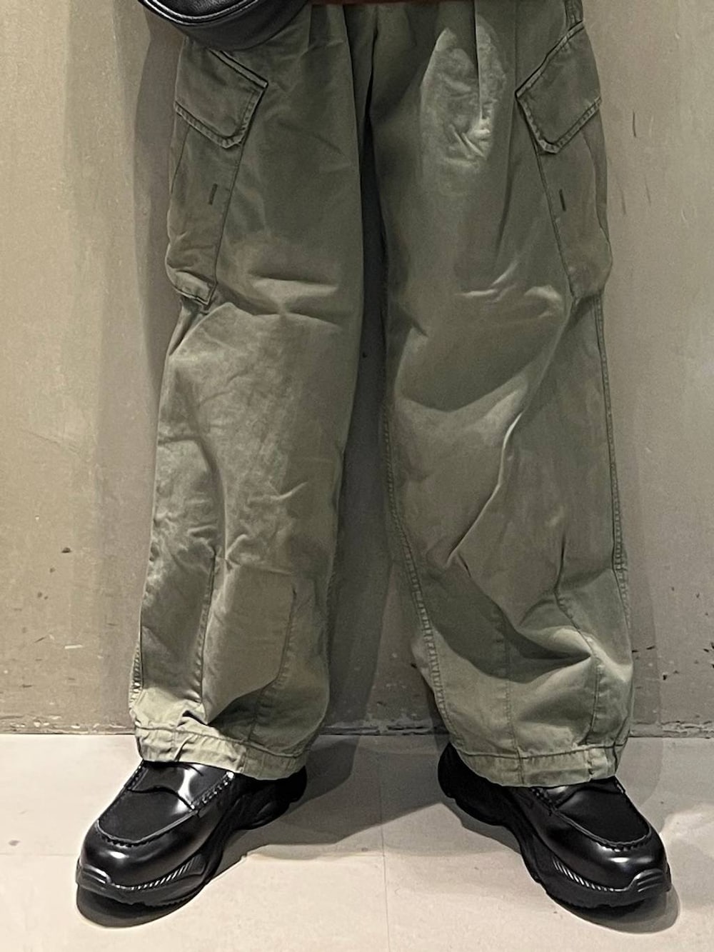 グリーン系のカーゴパンツ、ブラック系のショルダーバッグ、ブラック系のローファーを着用したメンズの夏コーディネートの3枚目の写真