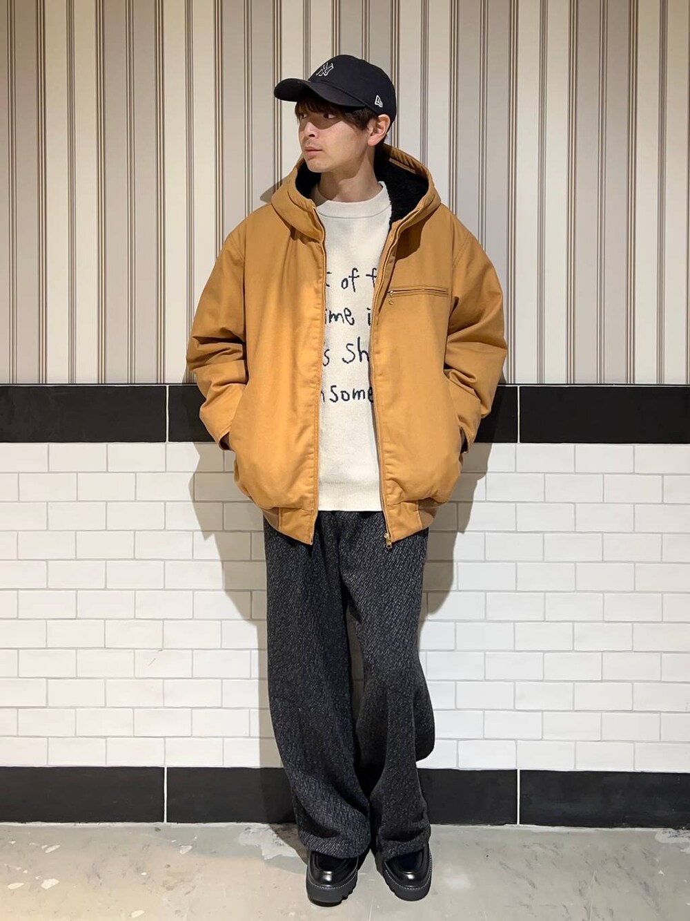 ブラウン系のブルゾン、ブラック系のドレスシューズ、グレー系のスラックスを着用したメンズの秋コーディネートの4枚目の写真