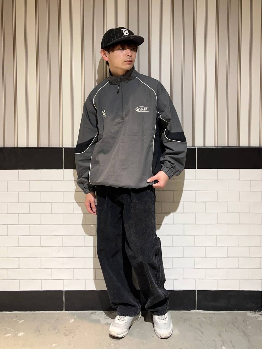 グレー系のスニーカー、グレー系のスウェット、ブラック系のキャップを着用したメンズの秋コーディネートの5枚目の写真