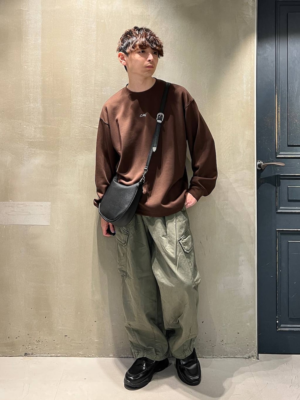 グリーン系のカーゴパンツ、ブラック系のショルダーバッグ、ブラック系のローファーを着用したメンズの夏コーディネートの4枚目の写真