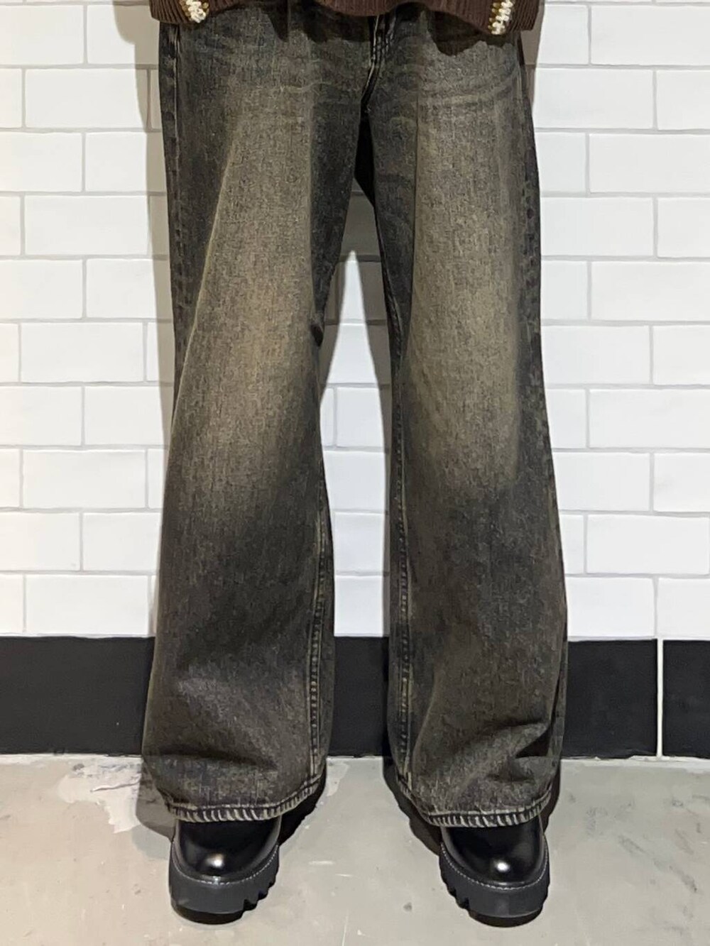 ブラック系のドレスシューズ、ブラウン系のニット/セーター、グレー系のデニムパンツを着用したメンズの冬コーディネートの3枚目の写真