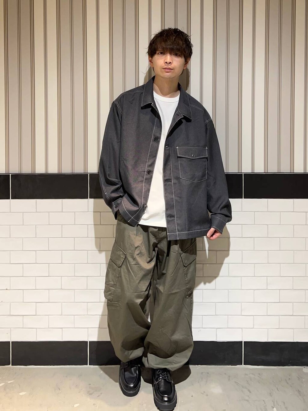 グリーン系のカーゴパンツ、グレー系のブルゾン、ホワイト系のTシャツ/カットソーを着用したメンズの秋コーディネートの2枚目の写真