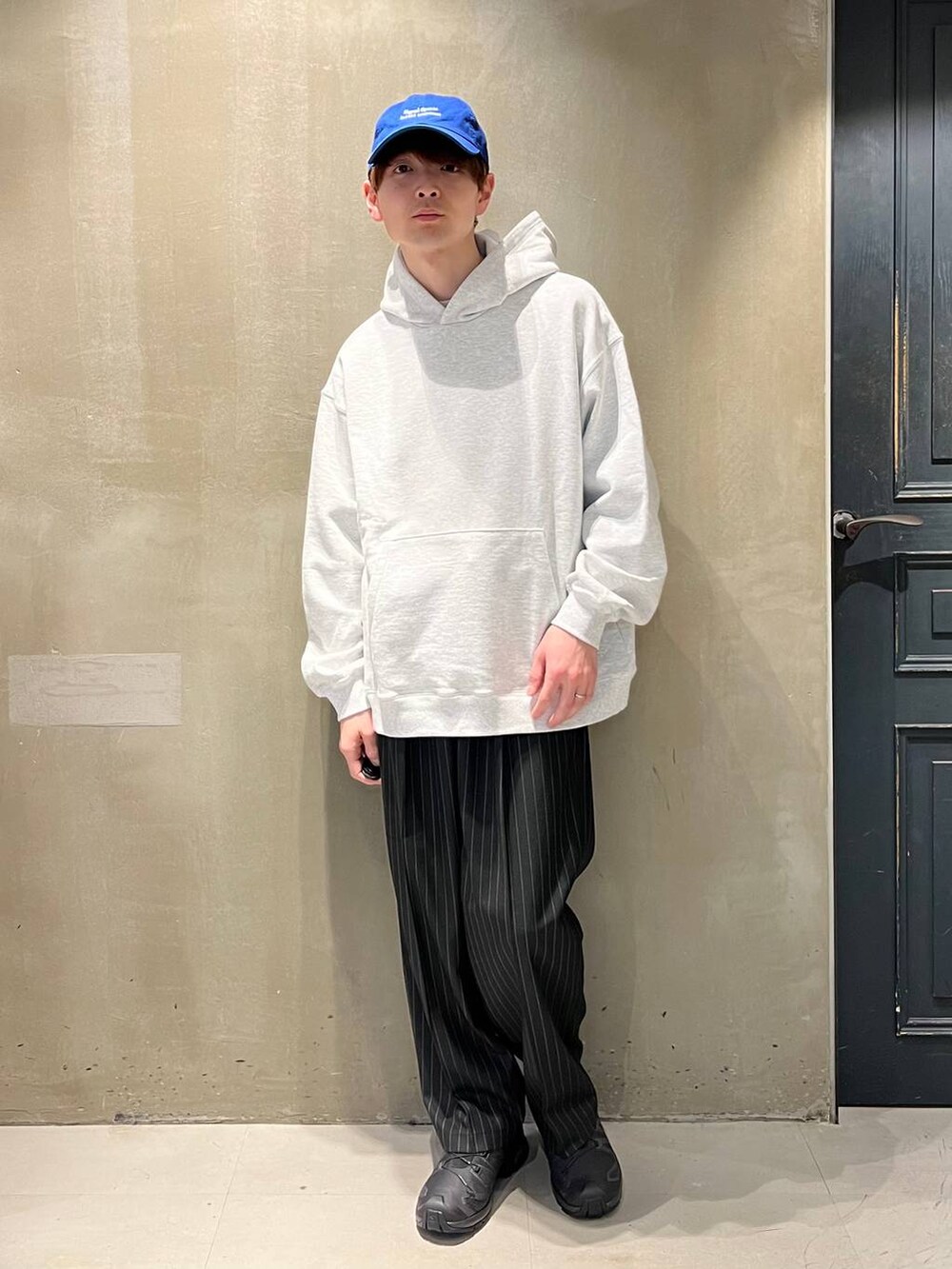 ブラック系のスニーカー、ブラック系のスラックス、その他のパーカーを着用したメンズの春コーディネートの6枚目の写真