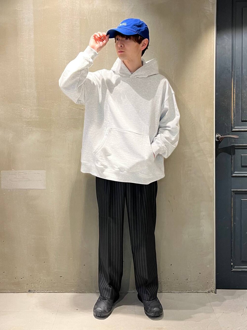 ブラック系のスニーカー、ブラック系のスラックス、その他のパーカーを着用したメンズの春コーディネートの7枚目の写真