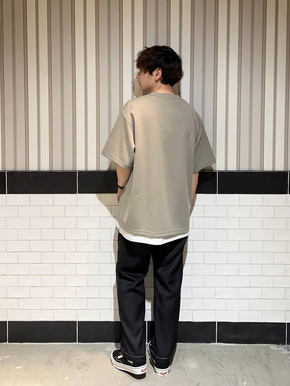 ホワイト系のタンクトップ、ブラック系のスラックス、ブラック系のスニーカーを着用したメンズの夏コーディネートの4枚目の写真