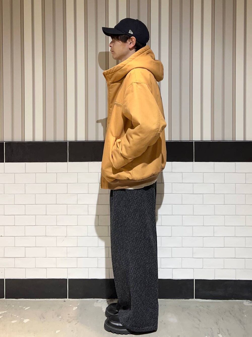 ブラウン系のブルゾン、ブラック系のドレスシューズ、グレー系のスラックスを着用したメンズの秋コーディネートの6枚目の写真