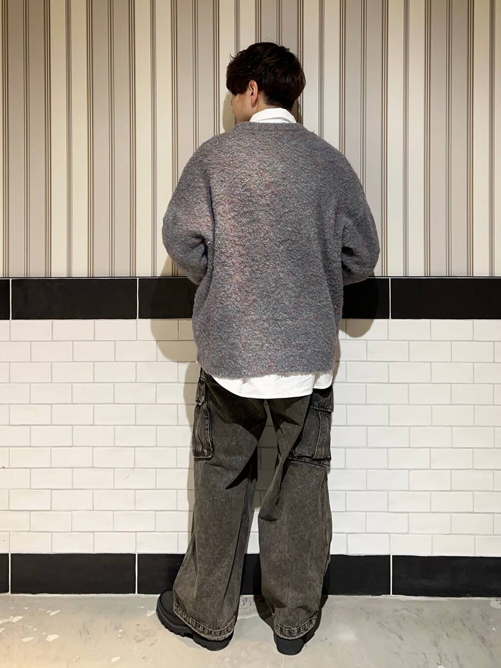 グリーン系のニット/セーター、ブラック系のドレスシューズ、ホワイト系のシャツ/ブラウスを着用したメンズの冬コーディネートの5枚目の写真