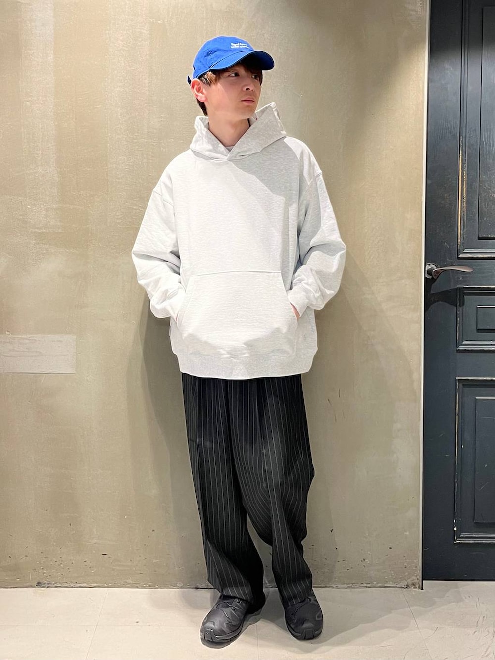 ブラック系のスニーカー、ブラック系のスラックス、その他のパーカーを着用したメンズの春コーディネートの2枚目の写真