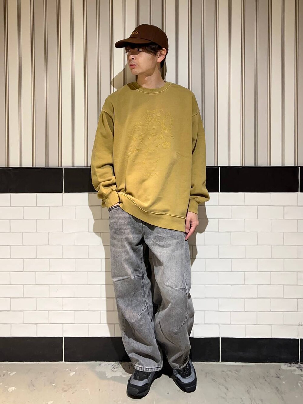 ブラック系のブルゾン、グレー系のデニムパンツ、ブラック系のスニーカーを着用したメンズの秋コーディネートの2枚目の写真