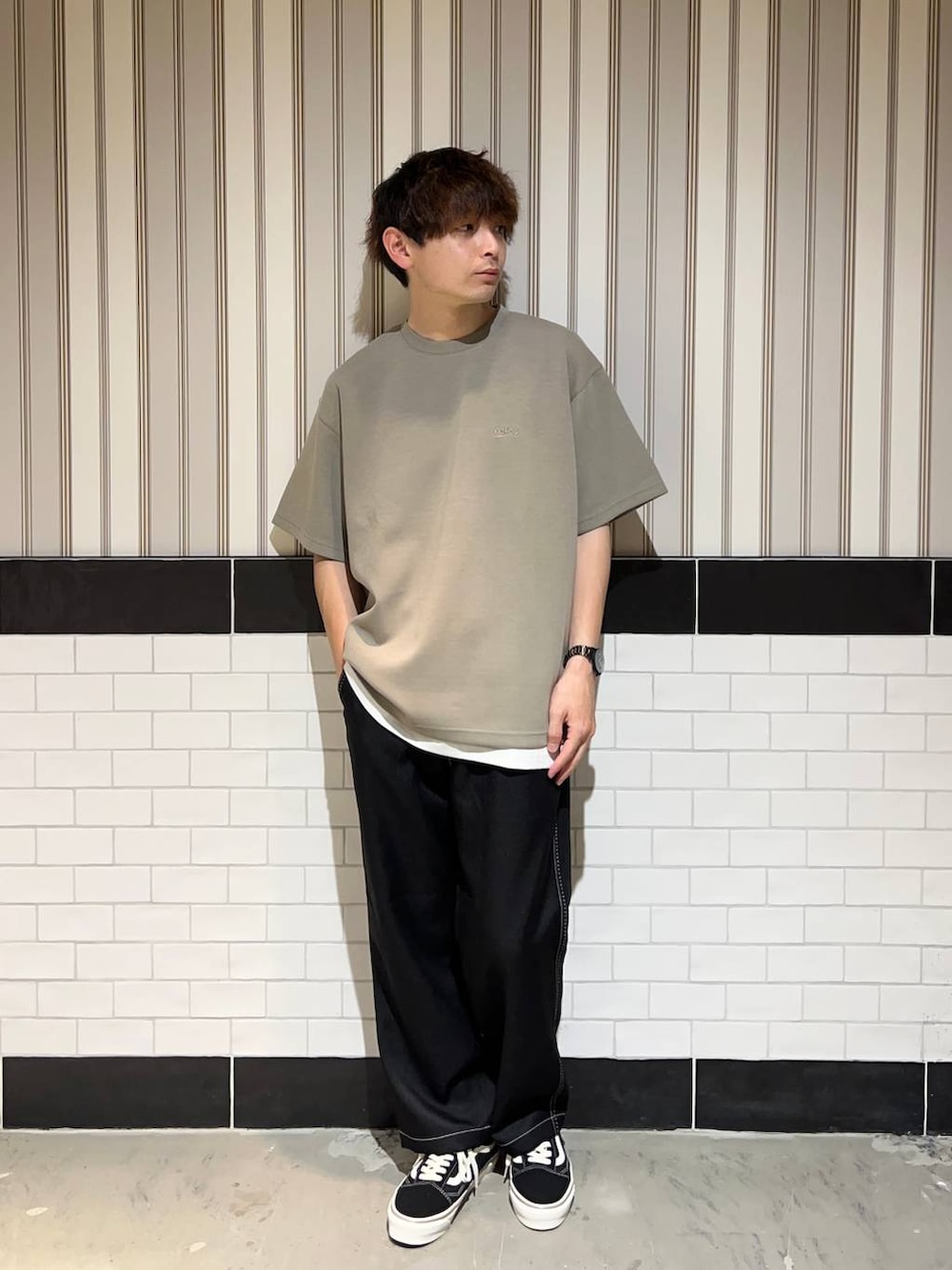 ホワイト系のタンクトップ、ブラック系のスラックス、ブラック系のスニーカーを着用したメンズの夏コーディネートの2枚目の写真