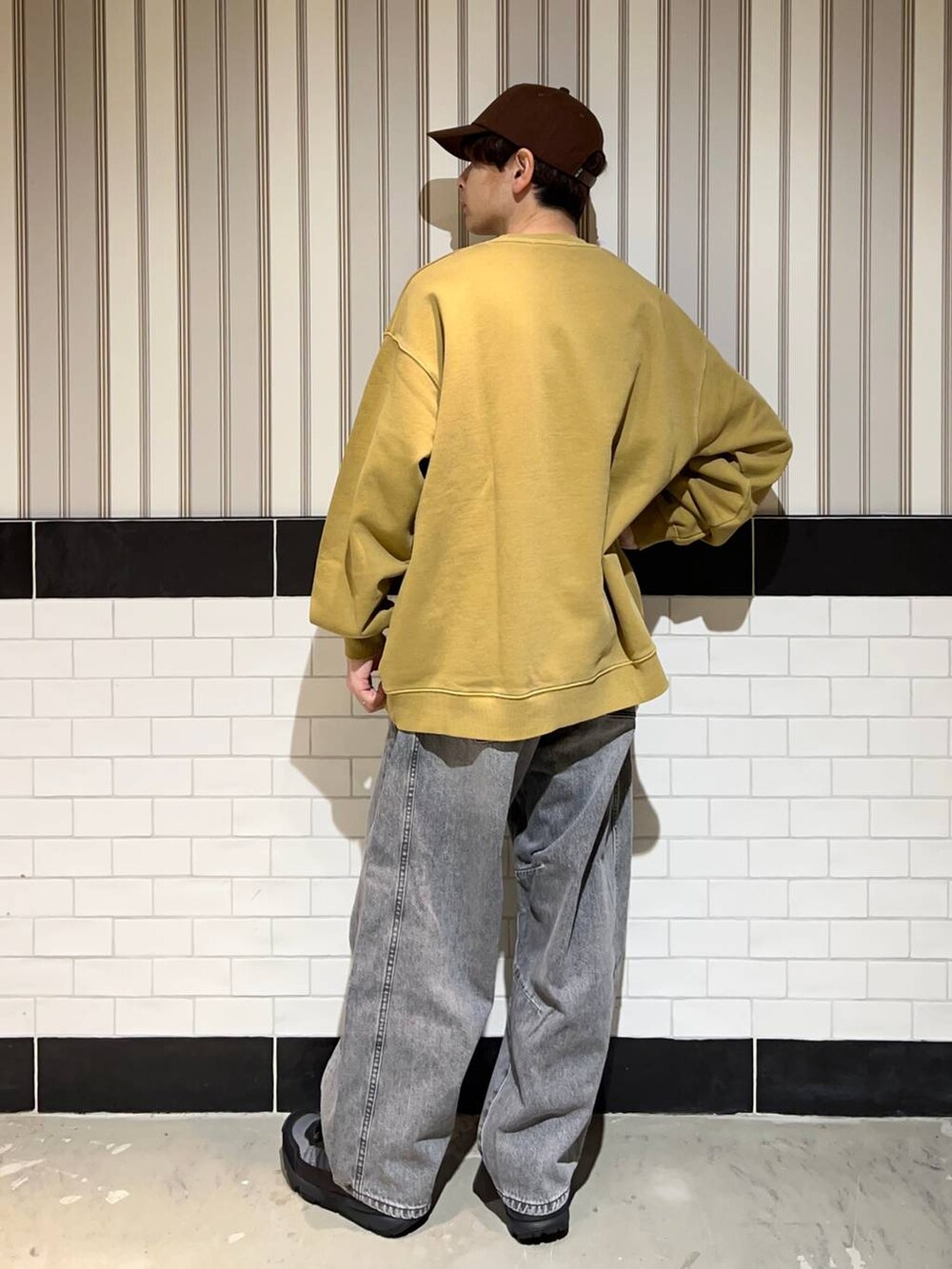 ブラック系のブルゾン、グレー系のデニムパンツ、ブラック系のスニーカーを着用したメンズの秋コーディネートの6枚目の写真