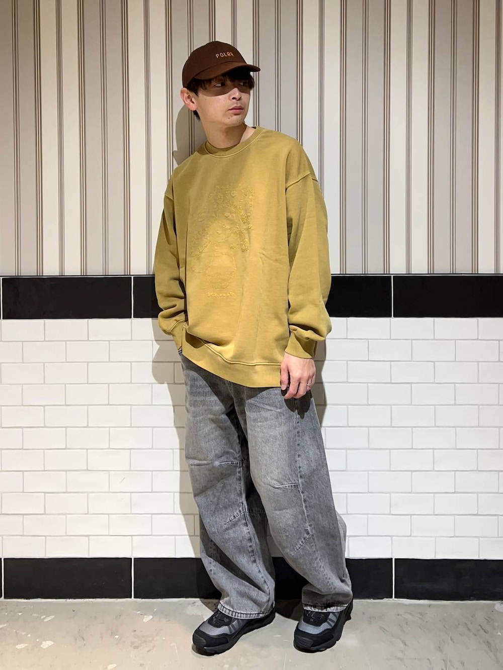 ブラック系のブルゾン、グレー系のデニムパンツ、ブラック系のスニーカーを着用したメンズの秋コーディネートの4枚目の写真