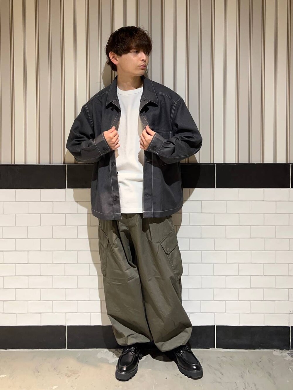 グリーン系のカーゴパンツ、グレー系のブルゾン、ホワイト系のTシャツ/カットソーを着用したメンズの秋コーディネートの3枚目の写真