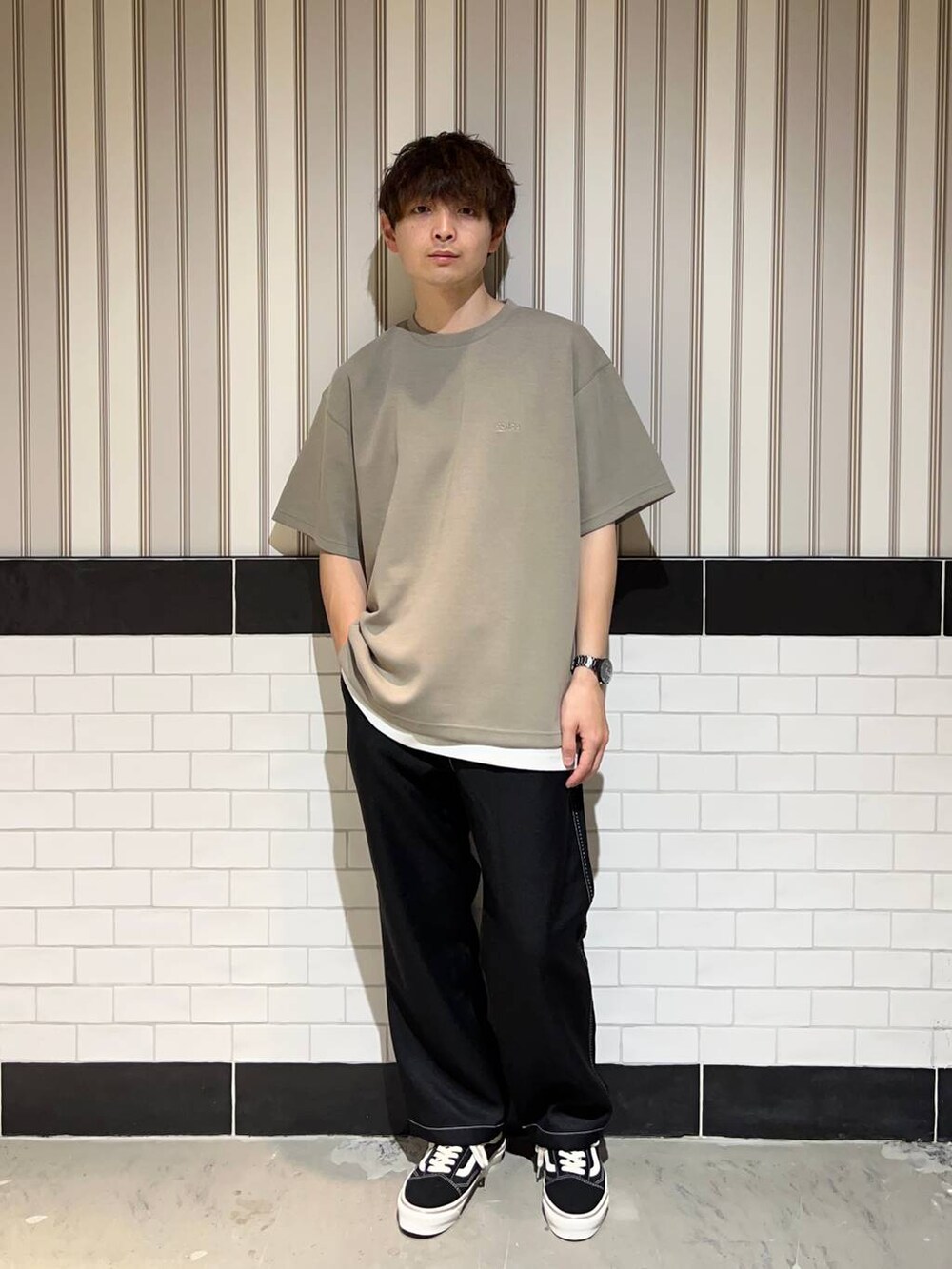 ホワイト系のタンクトップ、ブラック系のスラックス、ブラック系のスニーカーを着用したメンズの夏コーディネートの5枚目の写真